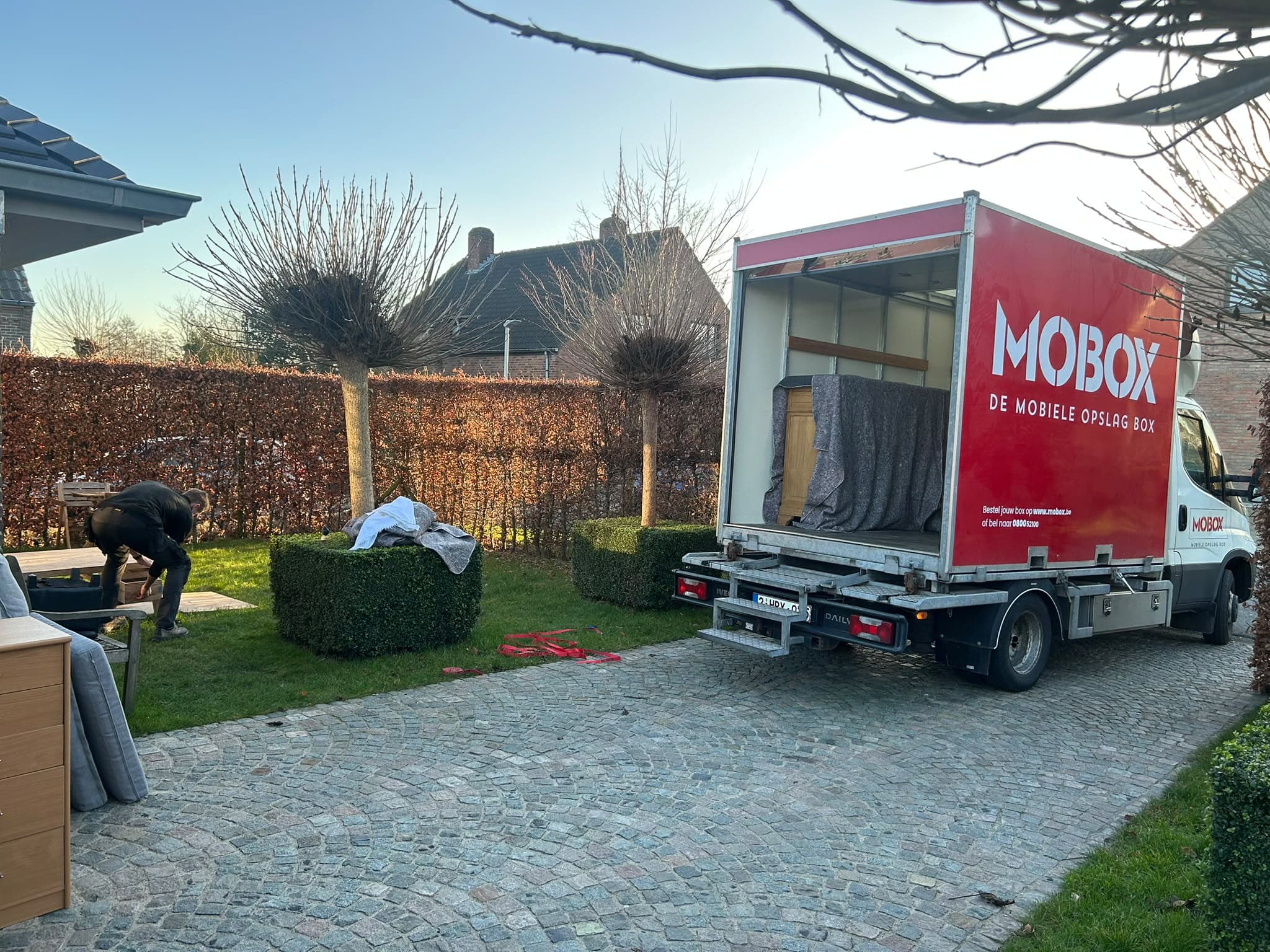 Meubels worden ingeladen in een MOBOX-box op de oprit